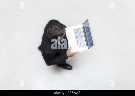 Geschäftsmann, stehen in der Lobby, mit Laptop-computer Stockfoto