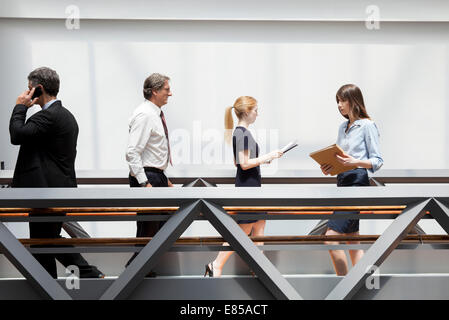 Business-Profis, die zu Fuß durch den Korridor Stockfoto