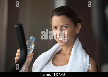Frau mit Mineralwasser im Health Club feuchtigkeitsspendende Stockfoto