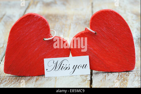 Verpassen Sie die Karte mit zwei roten Holzherzen Stockfoto