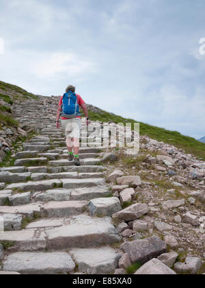 Eine Frau trägt einen Rucksack steigt der Wanderweg bis zum Ben Nevis Scotland UK Stockfoto