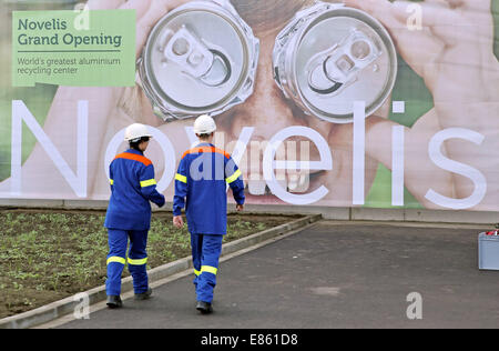 Nachterstedt, Deutschland. 1. Oktober 2014. Zwei Mitarbeiter der Firma vorbeigehen Novelis ein Firmen-Logo auf dem Firmengelände in Nachterstedt, Deutschland, 1. Oktober 2014. Nach Novelis ist es der führende Hersteller von gewalzten Aluminiumprodukten. Novelis eröffnet heute der weltweit größte Aluminium-recycling-Anlage. Das Unternehmen investiert 200 Millionen Euro in das neue Werk. In Zukunft wird es bis zu 400.000 Tonnen Aluminiumschrott verarbeiten und wieder als Aluminium-Barren für das Produktionsnetzwerk. für das neue Werk wurden 200 neue Mitarbeiter eingestellt. Foto: JAN WOITAS/DPA/Alamy Live-Nachrichten Stockfoto