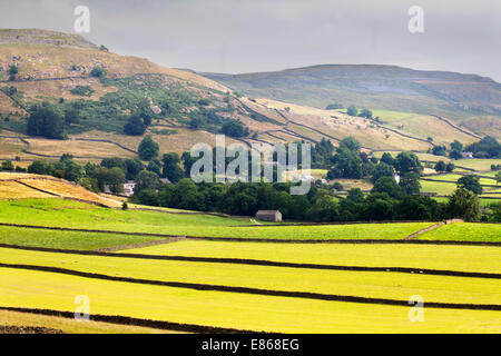 Das Dorf Wharfe schmiegt sich unterhalb Moughton Narbe in Crummack Dale bei Austwick Yorkshire Dales England Stockfoto