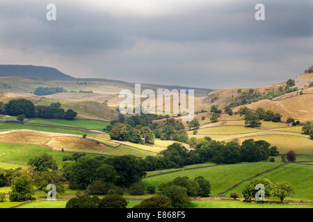 Sonnenlicht bricht durch dunkle Wolken über Crummack Dale bei Austwick Yorkshire Dales England Stockfoto