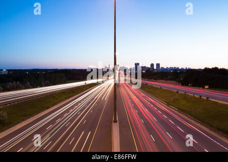 Lichtspuren auf einer Autobahn in der Abenddämmerung Stockfoto