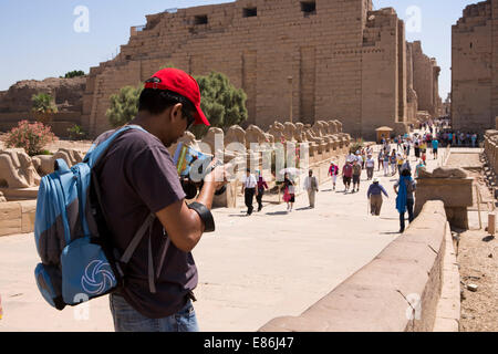 Ägypten, Luxor, Karnak-Tempel, Touristen fotografieren Avenue des Rams am Tempeleingang Stockfoto