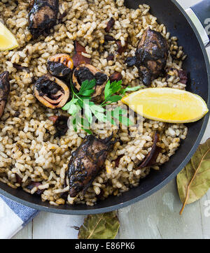 Reis mit Tintenfisch auf Tinte-Sauce auf Pfanne Stockfoto