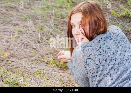 rote behaarte Frauen liegen auf Herbst Rasen Stockfoto