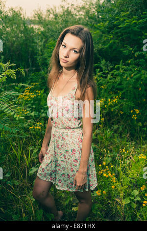 Schöne junge Frau steht in der Wiesenblumen. Natur genießen Stockfoto