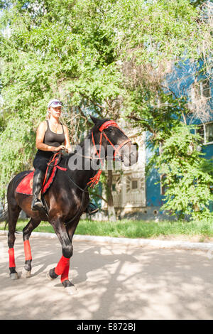 junge Frauen reiten auf Pferd auf der Straße Stockfoto