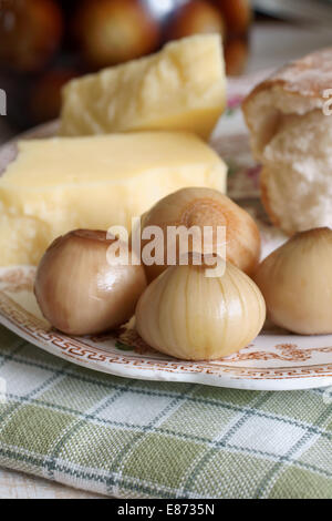 Hausgemachte eingelegte Zwiebeln, serviert mit Brot und Käse Stockfoto