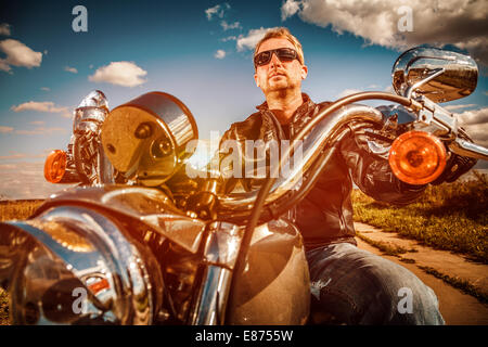Biker mit Sonnenbrille und Lederjacke auf einem Motorrad Stockfoto