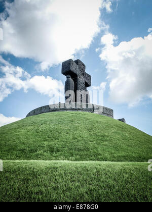 Das Denkmal zeigt zwei Menschen und ein Kreuz, das überragt die Räume von den deutschen Krieg Friedhof von La Cambe, in der Normandie Stockfoto