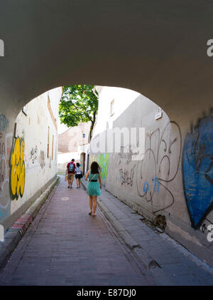 Schüler Fuß entlang einer Graffiti-bedeckten Gasse in Senamiestyje/Altstadt, Vilnius, Litauen Stockfoto