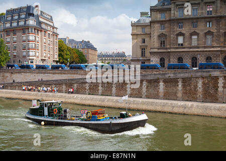 Kleine industrielle Boot segelt entlang des Kais Seineufer, Paris, Frankreich Stockfoto