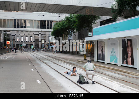 Hong Kong, China. 1. Oktober 2014.   Studenten und anderen Unterstützern der Occupy Central Bewegung versammelt sich in der Regierung Büros Gegend am Tamar. Alle Straßen in der Umgebung sind und öffentlichen Verkehr gesperrt. Dies bedeutet auch leere Straßen im Zentrum von Hongkong. Hier ein paar einander auf dem Tramgleis mitten auf der Straße zu fotografieren. Bildnachweis: Kees Metselaar/Alamy Live-Nachrichten Stockfoto