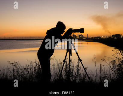 Fotografin bei Sonnenaufgang am Teesmouth National Nature Reserve, Hartlepool, UK. Stockfoto