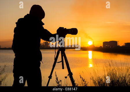 Fotografin bei Sonnenaufgang am Teesmouth National Nature Reserve, Hartlepool, UK. Stockfoto