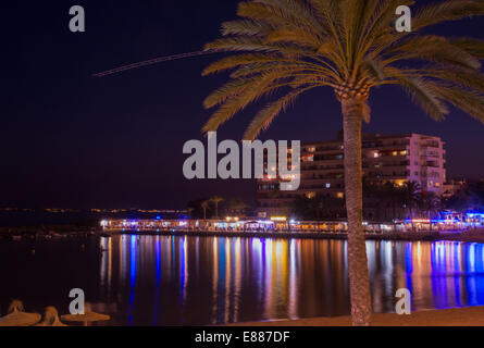 Nachtleben Cala Estancia mit Neonröhren über die Bucht und die Fluggesellschaft Flughafen Palma gesehen als Punkte über den Himmel abheben. Stockfoto