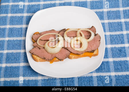 Öffnen Sie angesichts Sandwich geschnittenes Rindfleisch mit Zwiebelringen Stockfoto