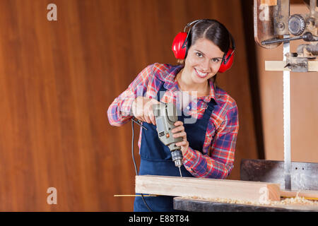 Zuversichtlich Zimmermann mit Bohrmaschine In Werkstatt Stockfoto