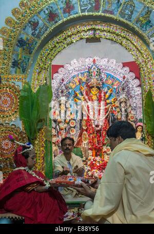 Calcutta, Indian state West Bengal. 2. Oktober 2014. Indisch-hinduistischen Anhänger verehren eine Mädchen als "Kumari" oder jungfräuliche Göttin vor einer Ton-Idol der Durga während des Durga Puja-Festivals in einem traditionellen Haus von Kalkutta, Hauptstadt des östlichen indischen Bundesstaat Westbengalen, 2. Oktober 2014. © Tumpa Mondal/Xinhua/Alamy Live-Nachrichten Stockfoto