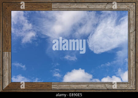 Alte Holz-Fenster mit blauen Himmel und Wolken. Stockfoto
