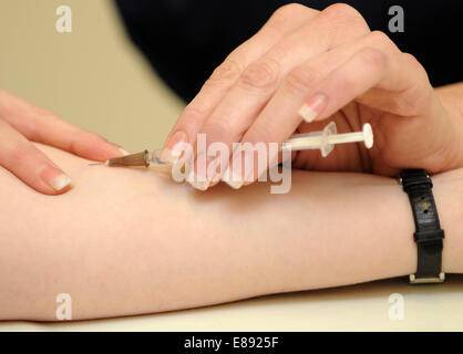 Eine Krankenschwester verwaltet einen Impfstoff mittels Injektion zu einem Patienten in einem medizinischen Zentrum im Rhondda, South Wales. Stockfoto