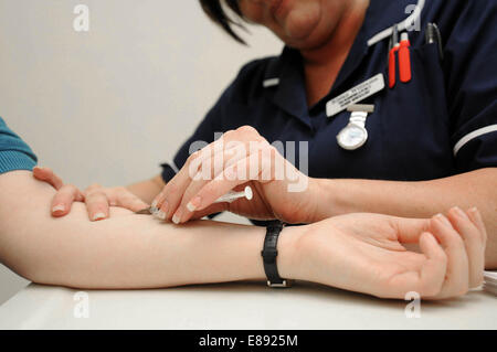 Eine Krankenschwester verwaltet einen Impfstoff mittels Injektion zu einem Patienten in einem medizinischen Zentrum im Rhondda, South Wales. Stockfoto