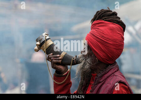 Sadhu weht traditionelle Signalhorn auf dem Weg zum Gangasagar Festival, Westbengalen, Indien Stockfoto