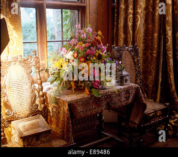 Stillleben mit bunten Spätsommer Blumenarrangement auf Tisch mit reich gemusterten Orientteppich Stockfoto