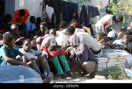 Garabulli, Libyen. 2. Oktober 2014. Einige illegale Einwanderer sitzen in einem Hof in Garabulli, Libyen, auf 2. Oktober 2014. Libyens Küstenwache am Donnerstag gerettet etwa 190 illegale Einwanderer in der Nähe der Küste Stadt Garabulli, etwa 60 Kilometer von Tripolis. Libyen ist seit langem ein Durchgangsort für Migranten, Malta, Italien und anderswo in Europa wegen seiner Nähe zu erreichen und relativ locker Grenzkontrollen. © Hamza Türkei/Xinhua/Alamy Live-Nachrichten Stockfoto