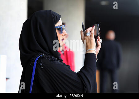 Dubai, Vereinigte Arabische Emirate, nimmt Frau in Tracht ein Foto mit ihrer Digitalkamera Stockfoto