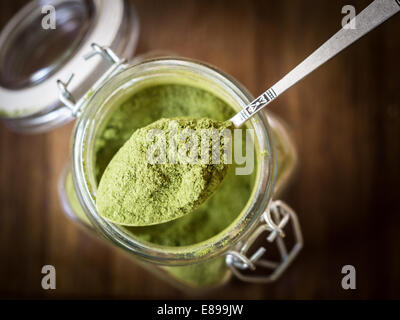 Moringa-Pulver auf einen Löffel in ein Glas. Hautnah. Stockfoto