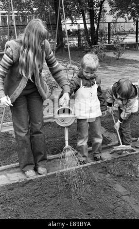 Berlin, DDR, Kinder im Vorschulalter und Lehrer arbeiten im Garten im Garten Schule Stockfoto