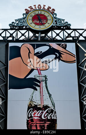 Orioles trinken Coca Cola Uhr und Oriole Maskottchen das Trinken aus einer Flasche Coca Cola, die am Eingang des Oriole Park ist. Stockfoto