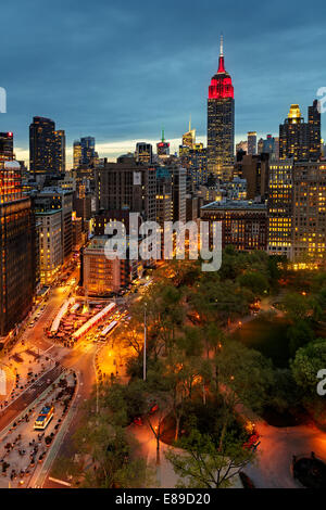 Flatiron District, Fifth Avenue und Broadway mit dem Empire State Building in rot und weiß beleuchtet. Stockfoto