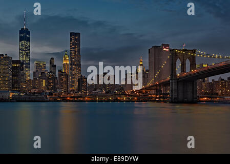 Ein Blick auf die Midtown Manhattan, New York Skyline der Stadt während der Dämmerung. Dieses Stadtbild umfasst ikonischen Wahrzeichen, wie z. B. das One World Trade Center (WTC) der Freedom Tower, der Brooklyn Bridge, New York von Gehry Gebäude, das Verizon Building, NYC städtischen Gebäude, das Woolworth Building zusammen mit anderen Wolkenkratzer in der Lower Manhattan Bereich geprägt. Das One World Trade Center und die Brooklyn Bridge ist auch als Schwarz und Weiß fine art print. Stockfoto