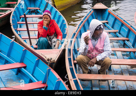 Nepalesische Mann und die Frau sitzt in seinem Boot am Phewa-See in Pokhara, Nepal. Stockfoto