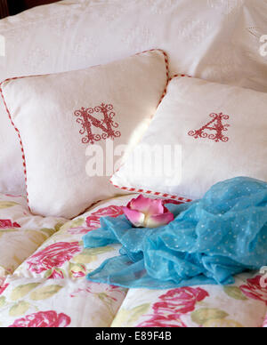Monogrammiert weißen Leinen Kissen auf dem Bett mit Türkis Schal und rose gemusterter quilt Stockfoto