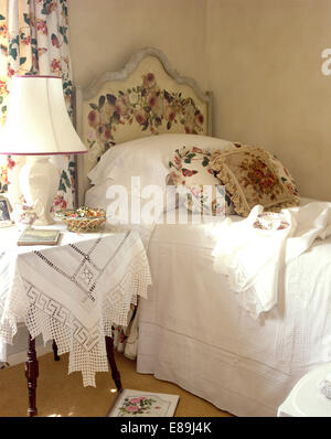 Weiße Baumwolle Bettdecke und rosa gemusterten Kissen Einzelbett mit rose pattened Kopfteil Stockfoto