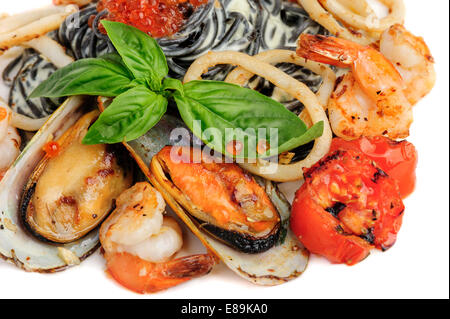 Schwarze Nudeln mit Meeresfrüchten und Basilikum Stockfoto