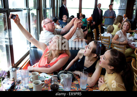 Schutzherren posieren für ein Selfie, wie Präsident Barack Obama Menschen im Magnolia Cafe in Austin, Texas, 10. Juli 2014 begrüßt. (Officia Stockfoto