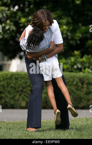 First Lady Michelle Obama umarmt ein Kind bei einem Drink Up Event auf dem South Lawn des weißen Hauses, 22. Juli 2014. (Offizielle Wh Stockfoto