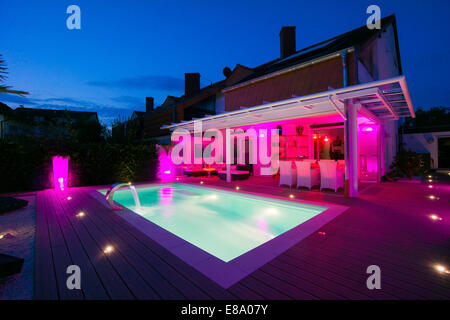 Private Reihenhaus mit Wintergarten, einen Pool und eine Terrasse mit Displaybeleuchtung in der Nacht, Deutschland Stockfoto