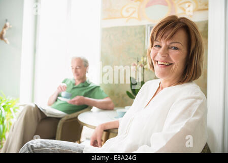 Porträt von senior Frau lächelnd während reifer Mann im Hintergrund Stockfoto