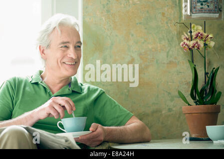 Reifer Mann halten Kaffee Tasse, Lächeln Stockfoto