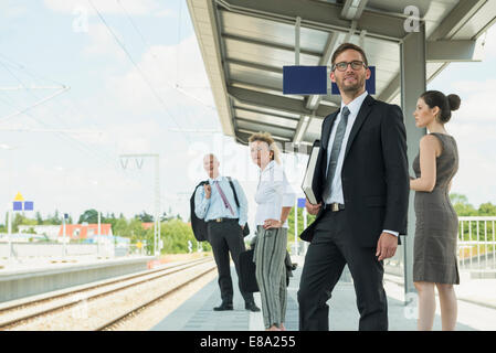 Vier Unternehmer warten auf Zug Stockfoto