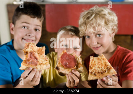 Drei Jungs mit Scheiben von pizza Stockfoto