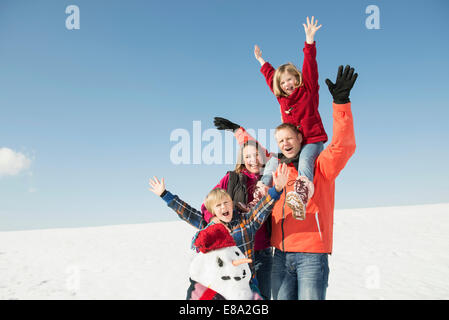 Familie mit Schneemann, lächelnd, Bayern, Deutschland Stockfoto